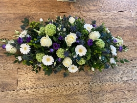 Purple green and white casket spray